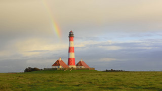 Lighthouse rainbow field mountains sunset 2 - a rainbow in the background and a rainbow in the sky above free wallpaper