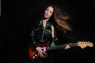 Woman guitar posing black background - a black background behind her free wallpaper