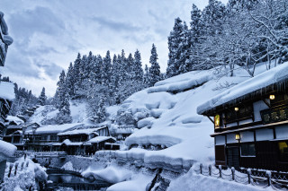 Snowy resort stream trees buildings - free winter wallpaper