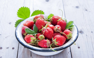 Bowl strawberries leaves wooden table - free hearts wallpaper