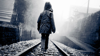 Person walking train track rain - liminal free wallpaper