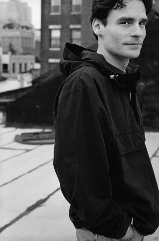 Man black jacket jeans hoodie - a city skyline in the background free wallpaper for mobile