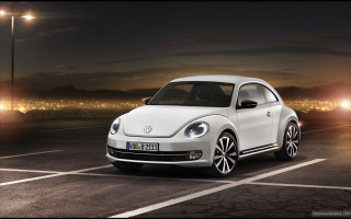 White volkswagen beetle night parking - a city in the distance free wallpaper