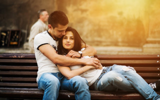 Romantic hugging couple with man - a bench together free wallpaper