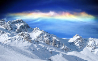 Rainbow snowy mountain range distance - a rainbow in the sky above free wallpaper