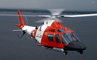 Red white helicopter flying ocean - over the ocean water free wallpaper