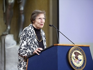 Woman podium microphone statue background - head and shoulders portrait free wallpaper for desktop