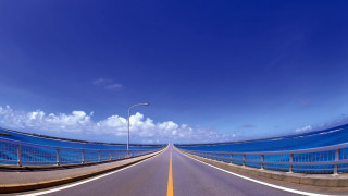 Wide road streetlight ocean bridge - a blue ocean in the background free wallpaper