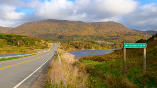 Road sign river mountains clouds - a road sign free wallpaper