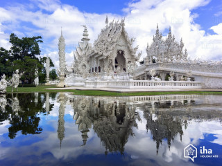 White building water sky clouds - a large body of water in front free wallpaper