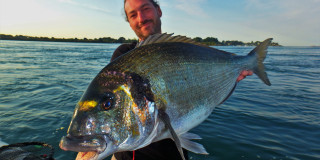 Man holding large fish boat - a sky background and a body of water free wallpaper