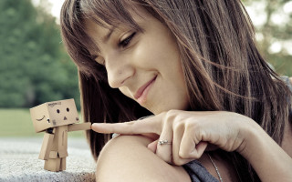 Woman holding wooden toy figure - a sad face free wallpaper