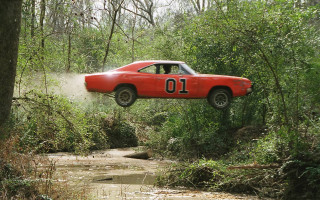 Red car jumping muddy stream - the front of the car free wallpaper