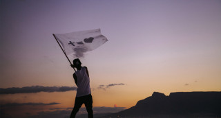 Man holding flag beach sunset - a mountain in the background and a sky free wallpaper