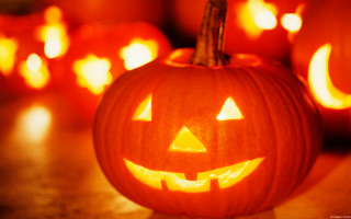 Pumpkins with faces candles blurry - free halloween wallpaper
