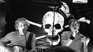 Singing duo skull wall microphones - the wall behind them free wallpaper