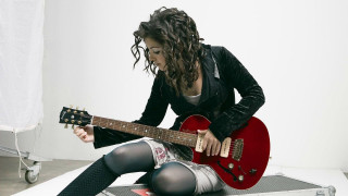 Woman sitting floor red guitar - a white background behind her free wallpaper