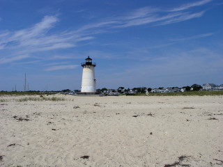 Lighthouse sandy beach blue sky - a sandy beach free wallpaper for desktop