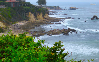 Beach people cliff house scenery - a cliff in the background free wallpaper