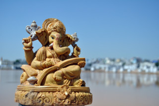Ganeshi statue bench water city - shallow depth of field free wallpaper