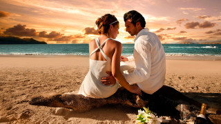 Man woman sitting log beach 2 - the ocean in the background free wallpaper