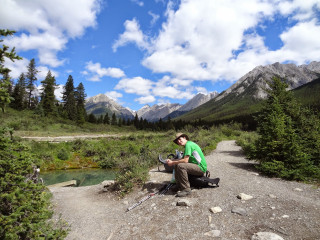 Man sitting rock river mountains - his lap free wallpaper for desktop