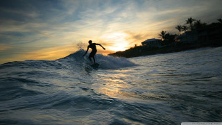 Man surfing wave sunset house - a house in the background free wallpaper
