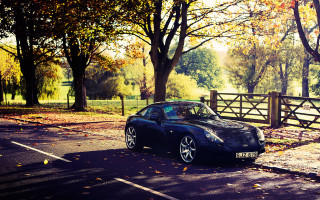 Black sports car autumn fence - the side of the road in front free wallpaper