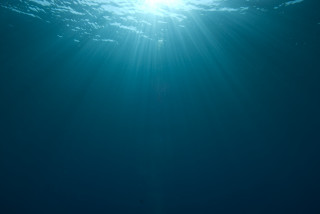 Person riding surfboard underwater sunbeam - a person riding free wallpaper