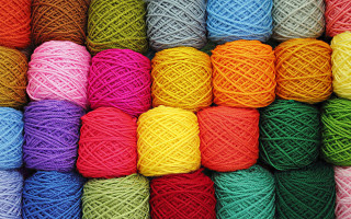 Multicolored yarn stacked row table - a rainbow of colors free wallpaper
