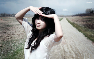 Woman standing dirt road field - sunny day free wallpaper