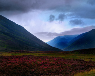 Mountain range grassy field cloudy - a grassy field below free wallpaper