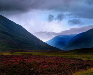 Mountain grassy field cloudy sky - a grassy field below free wallpaper for desktop