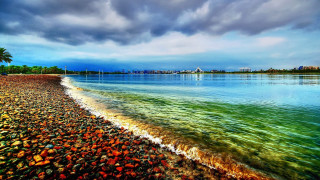Beach water cloudy sky city - a city in the distance free wallpaper