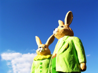 Rabbit statues green outfits sunny - blue sky in the background free wallpaper