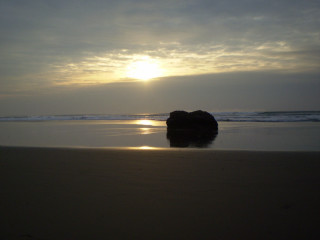 Rock beach sunset clouds horizon - a sandy beach under a cloudy sky free wallpaper