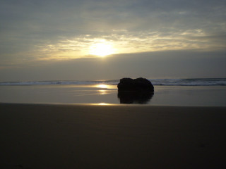 Rock sandy beach cloudy sunset - a sandy beach under a cloudy sky free wallpaper