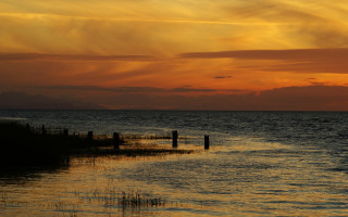 Sunset ocean boat fence mountains - a distant mountain range in the distance free wallpaper