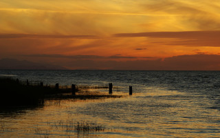 Sunset ocean boat fence mountain 2 - a distant mountain range in the distance free wallpaper