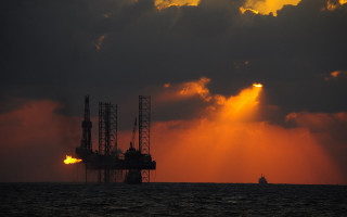 Oil rig water cloudy sunset 3 - a large body of water under a cloudy sky free wallpaper