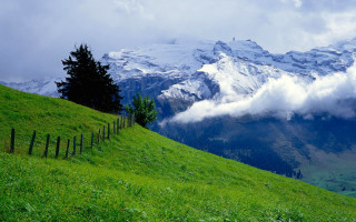 Mountain fence grassy field clouds - a grassy field below free wallpaper