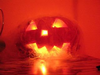 Glowing pumpkin candle face dark - free halloween wallpaper