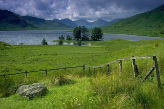 Grassy field wooden fence lake - alexander johnston free wallpaper