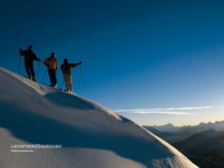 Three people snow covered slope - top of a snow free wallpaper