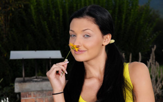 Woman holding flower cigarette yellow - her mouth and a cigarette free wallpaper