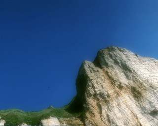 Rock formation bird flying blue 2 - a small patch of grass free wallpaper