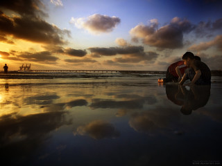 Woman kneeling beach boat sunset - a boat in the background free wallpaper