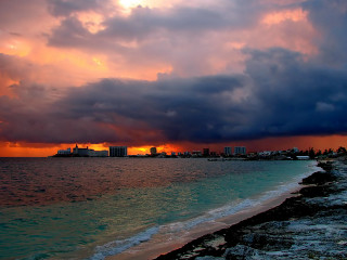 Sunset beach city clouds water 3 - a city in the distance free wallpaper for desktop