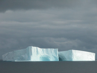 Large iceberg floating ocean cloudy 2 - the ocean under a cloudy sky free wallpaper