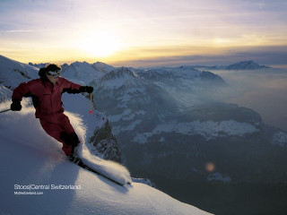 Person red snow suit skiing - a mountain range in the distance free wallpaper
